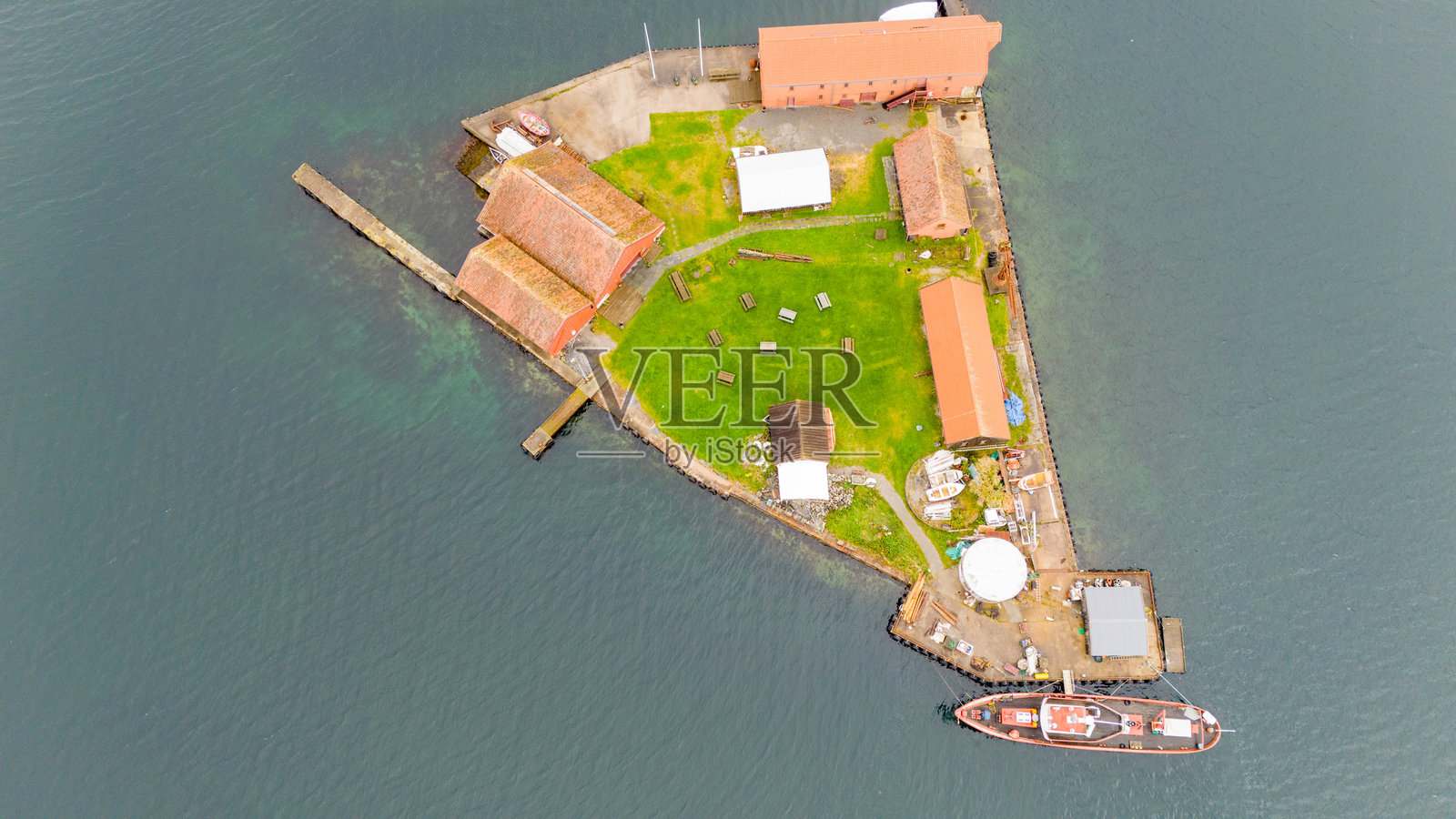 小岛的鸟瞰图，岛上有建筑和停靠的船只照片摄影图片