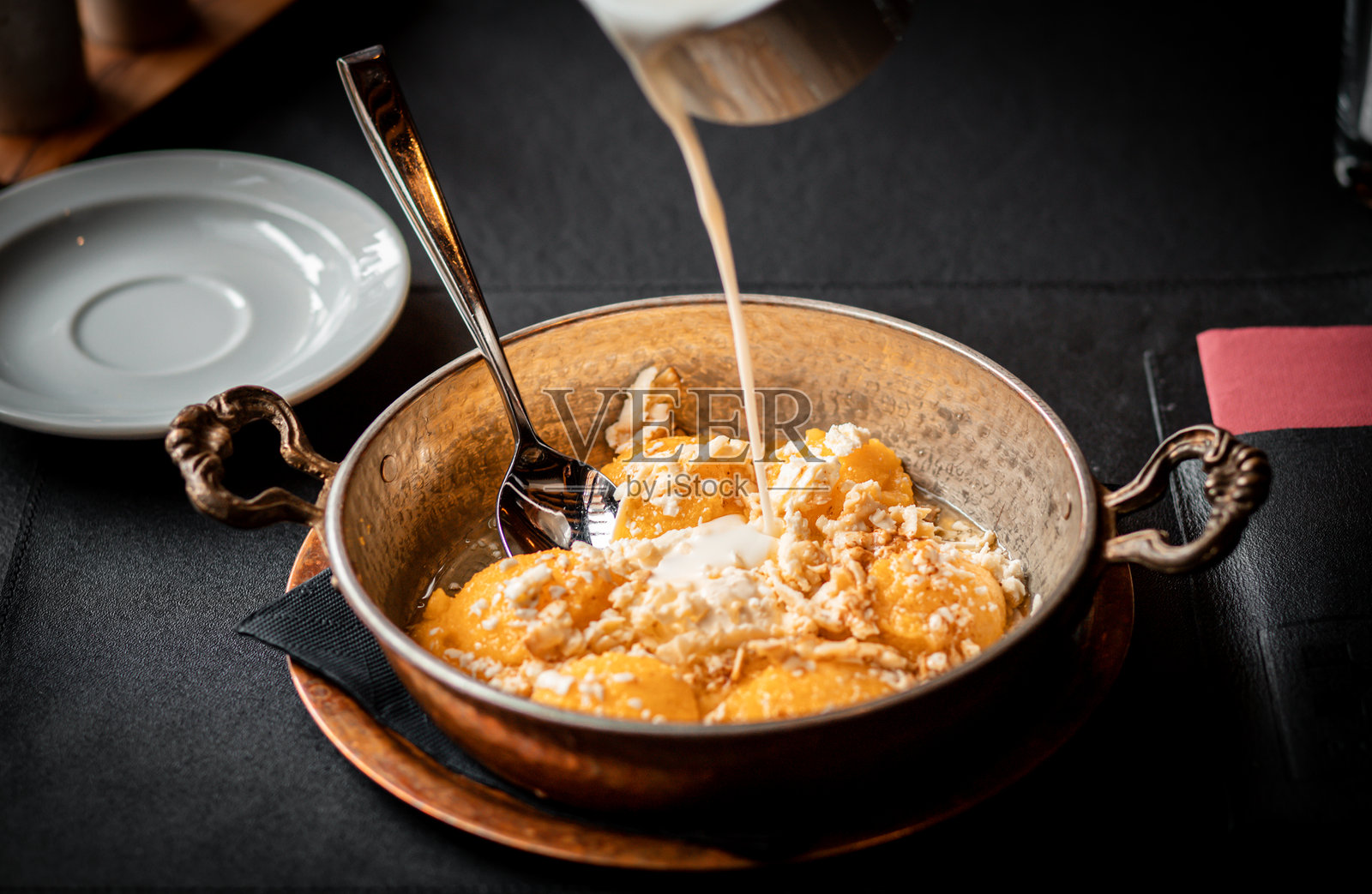 美味的芒果甜点配奶油，盛放在优雅的金属碗中照片摄影图片