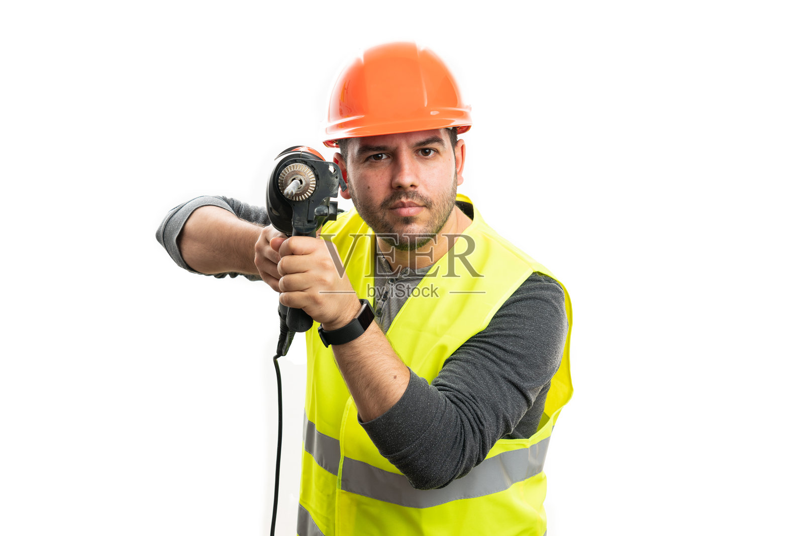 严肃的建筑工人穿着背心和安全帽，指着钻孔工具照片摄影图片
