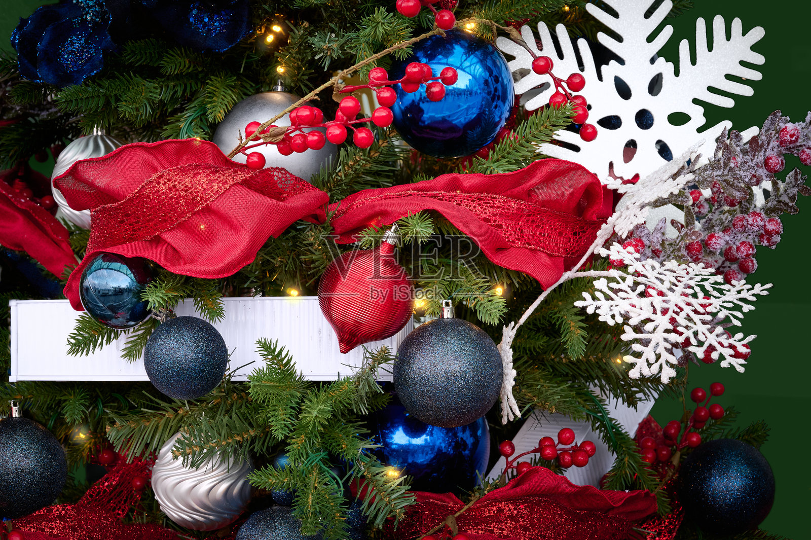 装饰有蓝色和红色装饰品的圣诞树。照片摄影图片