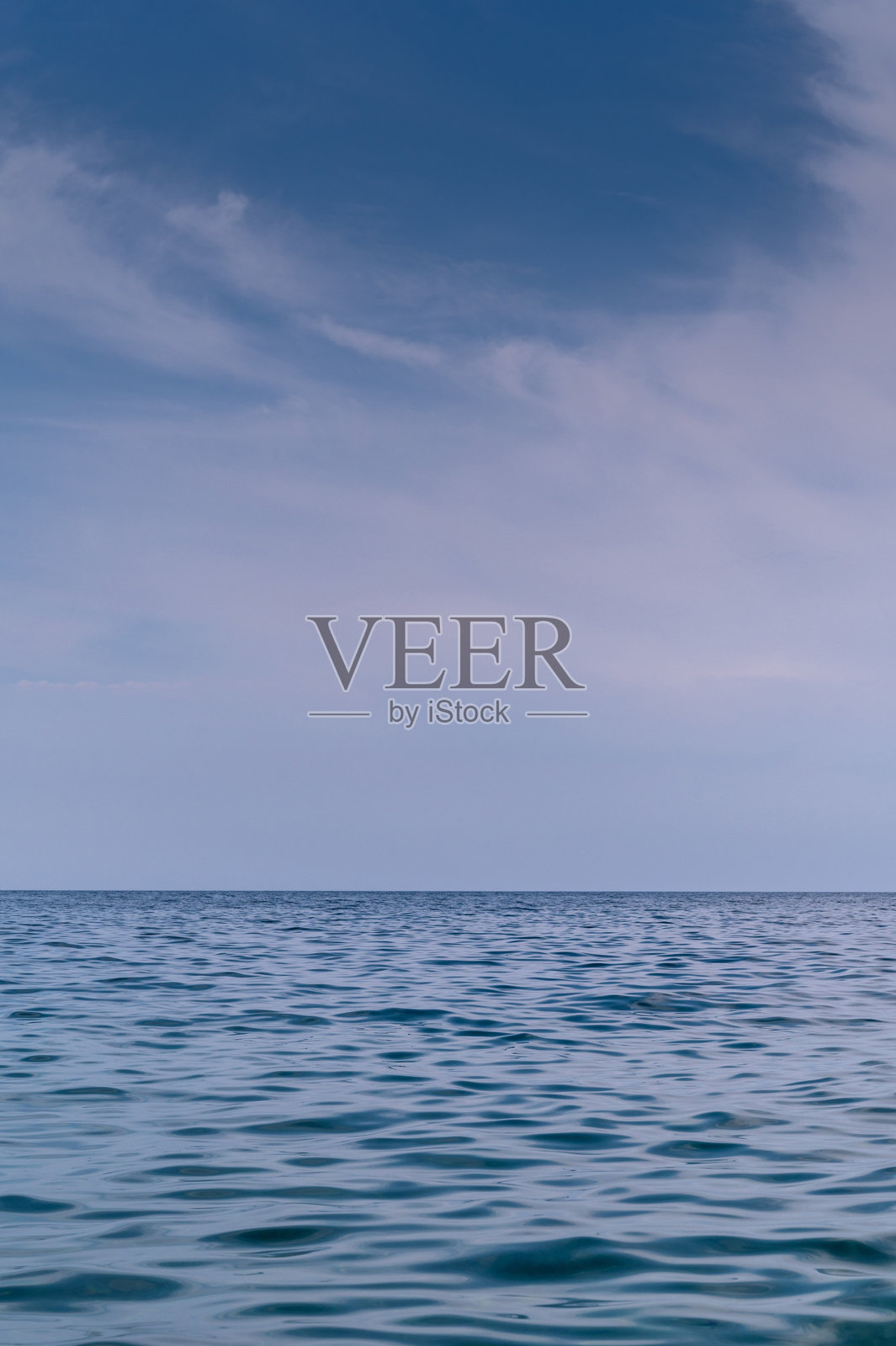 蓝色海面延伸至地平线。照片摄影图片