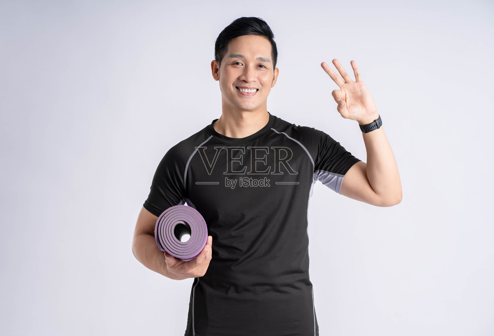 穿着运动服的男子在白色背景前摆姿势的肖像照片摄影图片