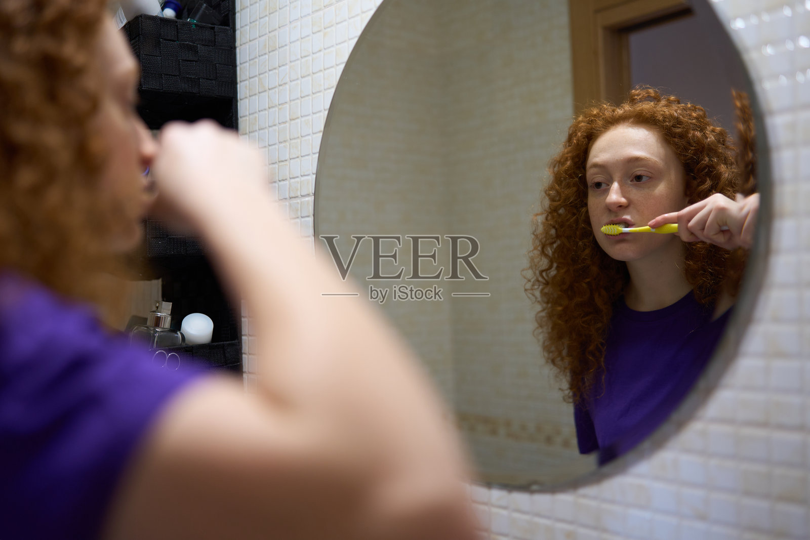 年轻女性在浴室镜子前刷牙照片摄影图片