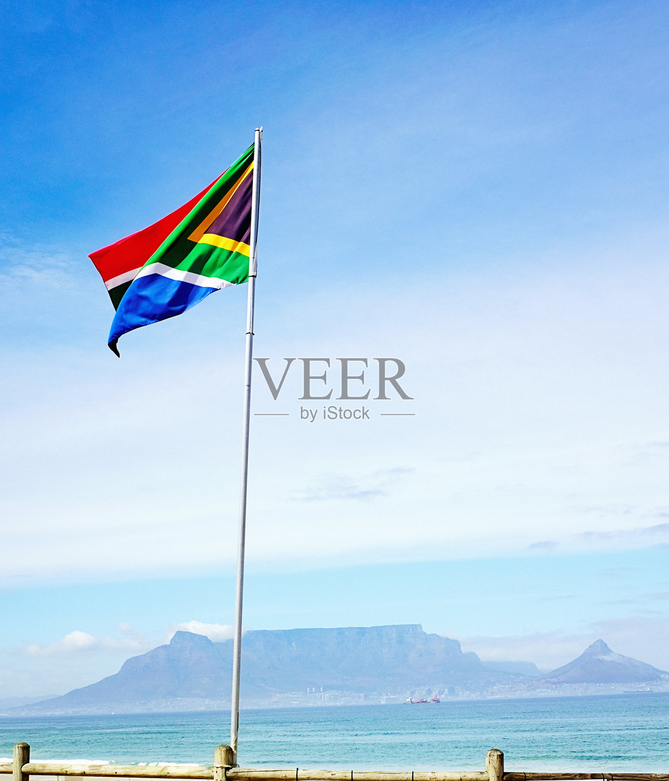 南非国旗在桌湾的背景下与开普敦的地标桌山一起飘扬照片摄影图片
