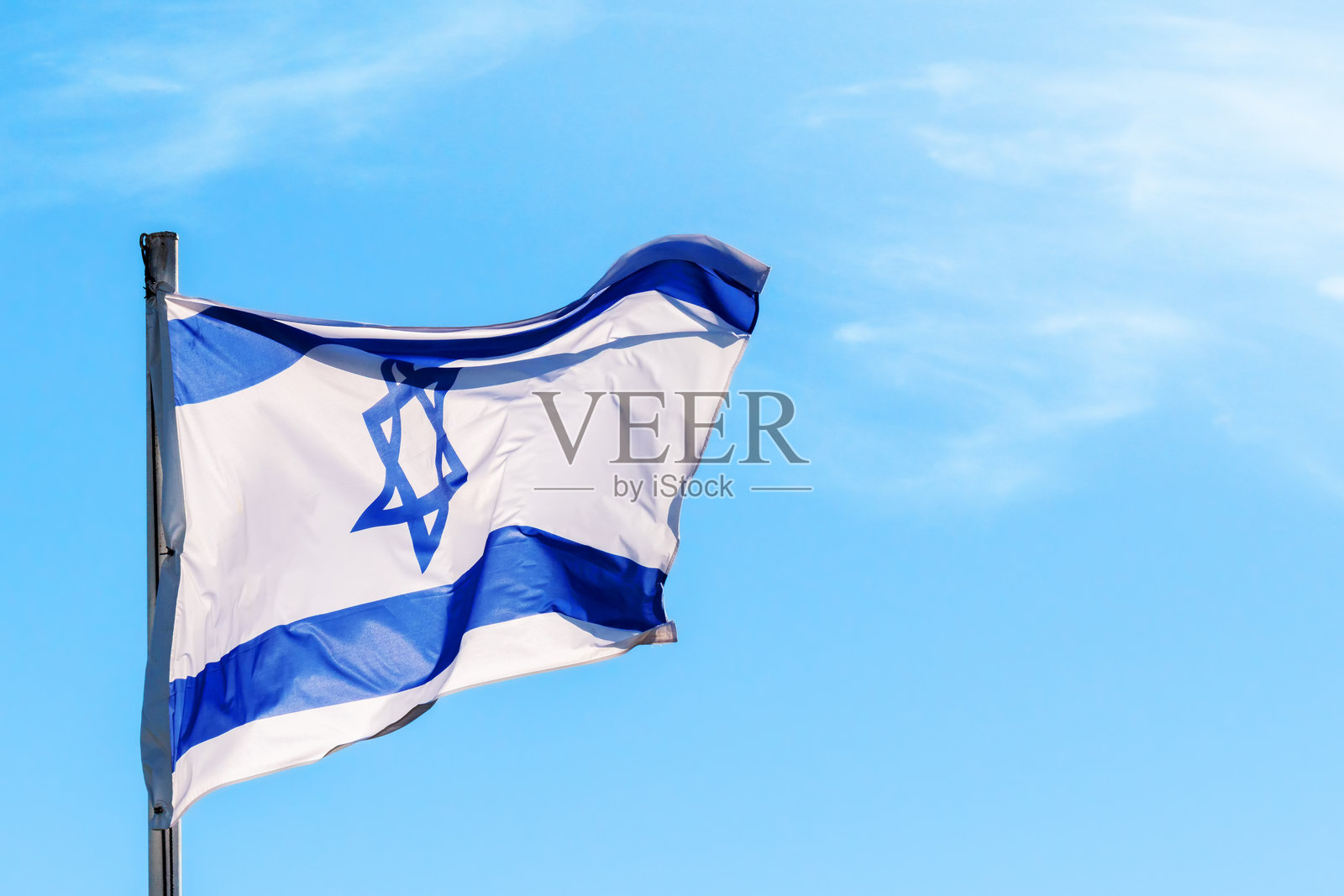 以色列国旗在蓝天背景下飘扬照片摄影图片