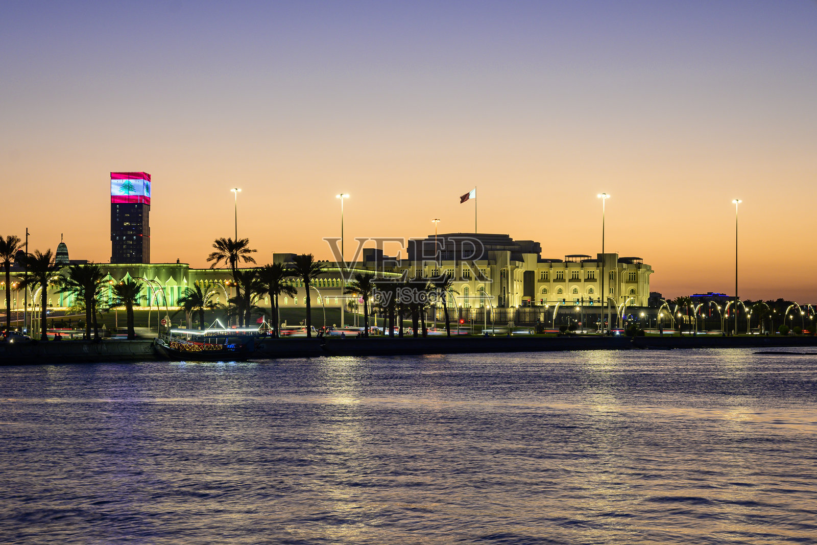 从多哈港口俯瞰夜间灯火辉煌的国会大厦壮丽景色照片摄影图片