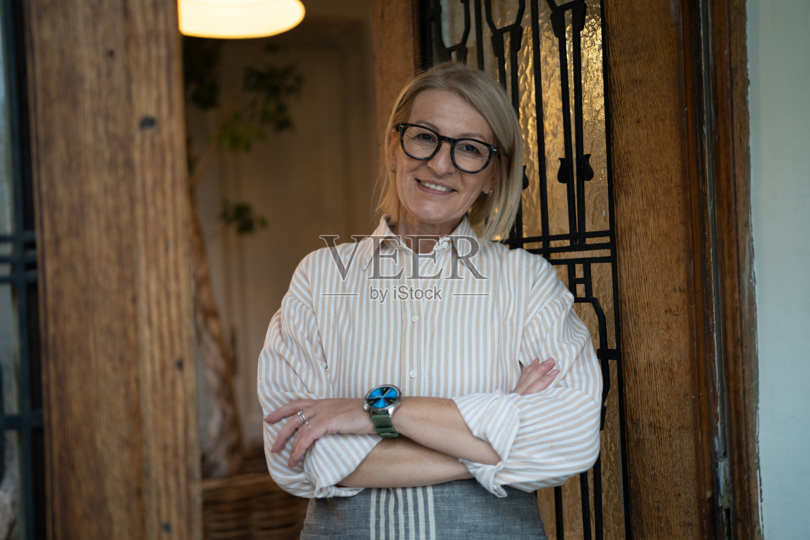 餐厅入口处交叉双臂的女服务员肖像照片摄影图片