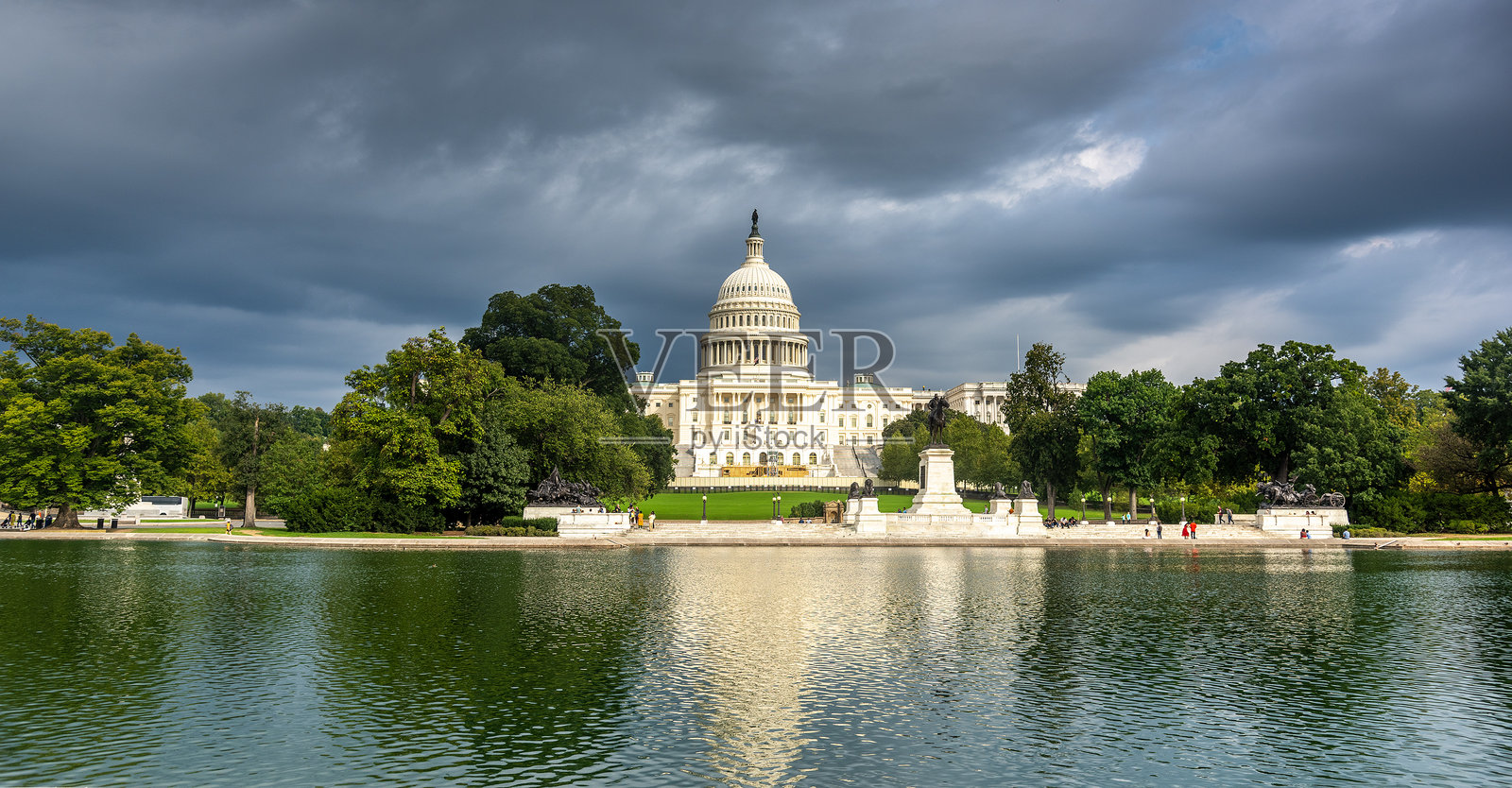 美国国会大厦在阴沉的灰色天空下倒映在水池中照片摄影图片