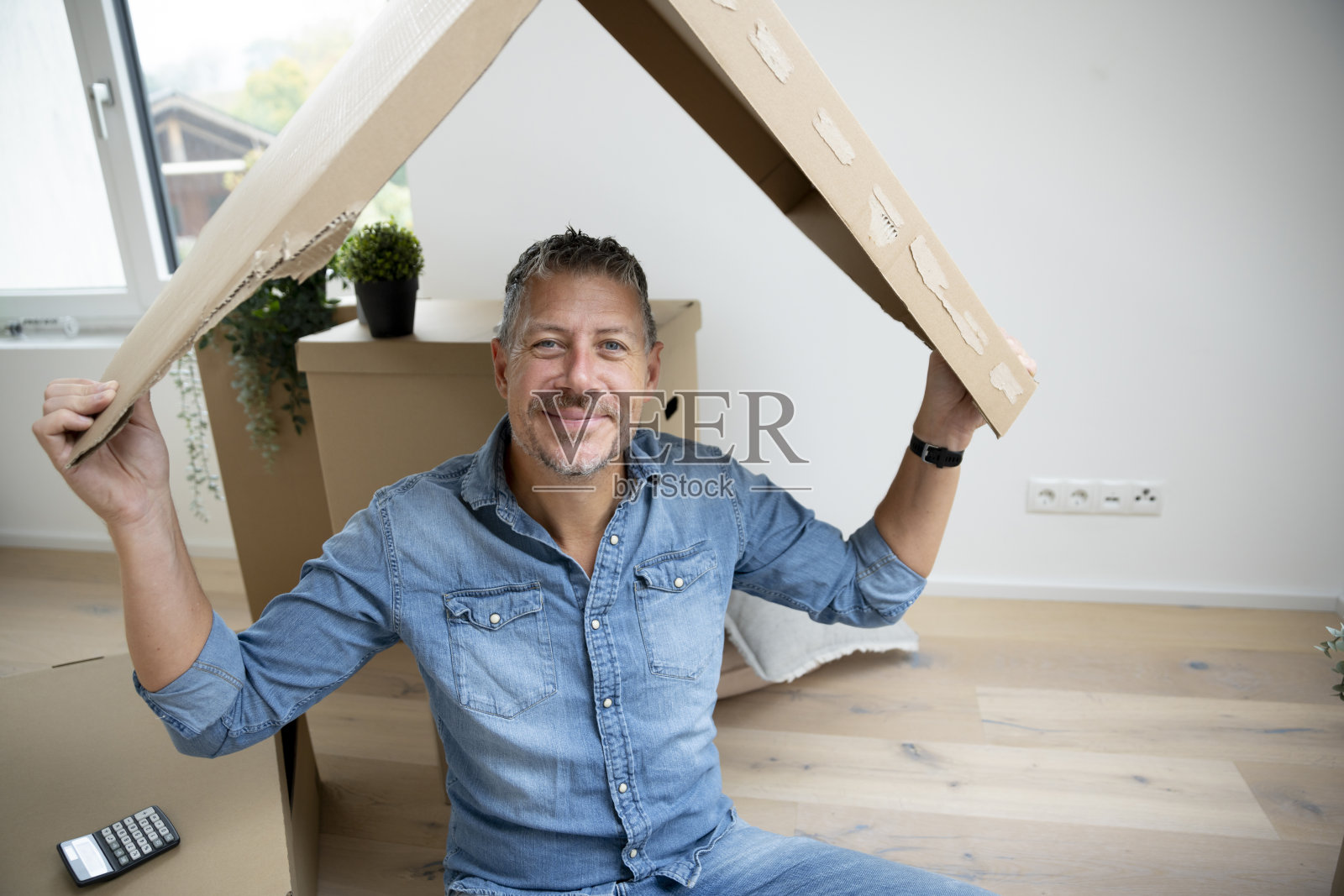 新公寓里的男人与纸板屋顶，房子，阁楼照片摄影图片