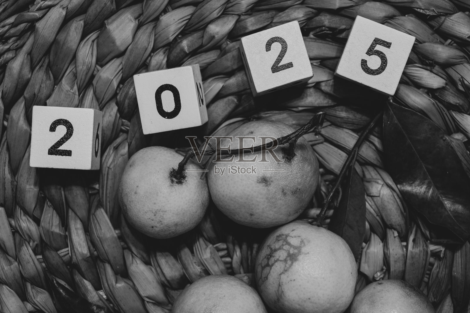 橘子和写有2025年的木块放在一个草编篮子里照片摄影图片