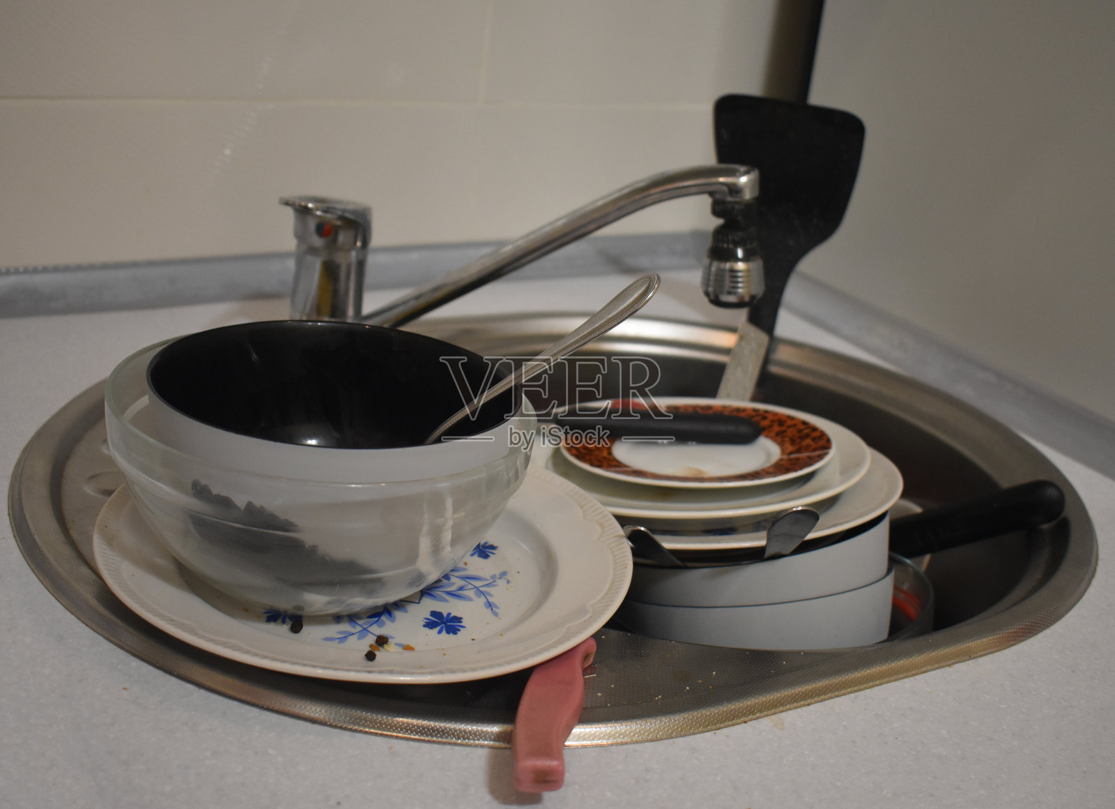 脏乱的厨房用具、盘子和杯子。水槽里堆满了未洗的脏碗碟。厨房里的混乱。家里的混沌。懒惰。杂乱的公寓。凌乱的餐具和餐具。照片摄影图片