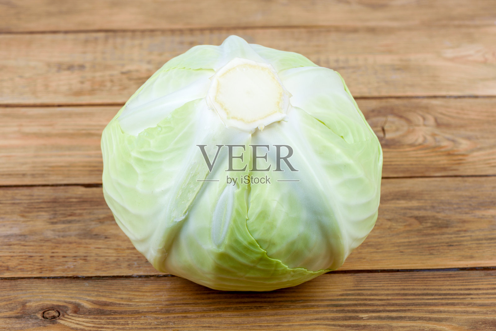 一颗卷心菜在木质背景上的特写。照片摄影图片