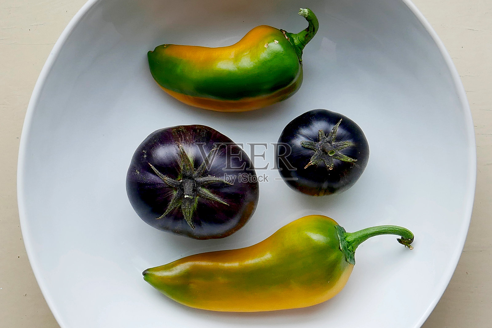 紫黑色番茄与青椒在碗中照片摄影图片