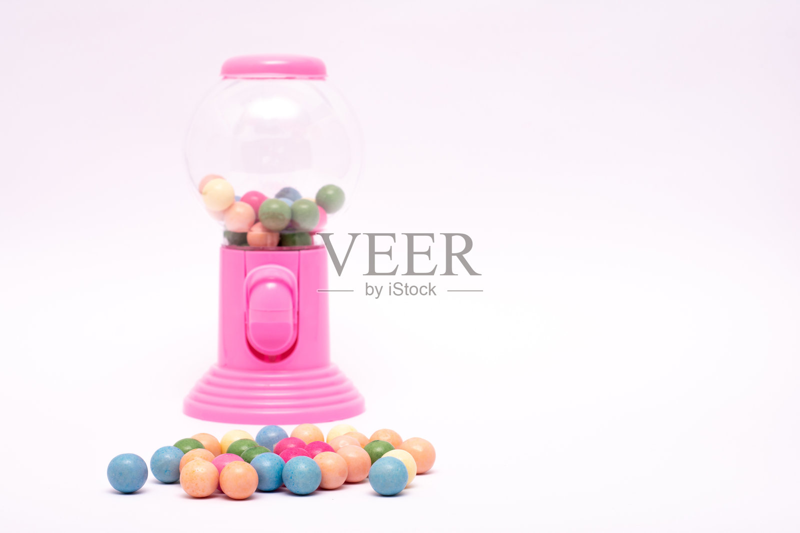 粉色的泡泡糖机里装满了五颜六色的泡泡糖照片摄影图片