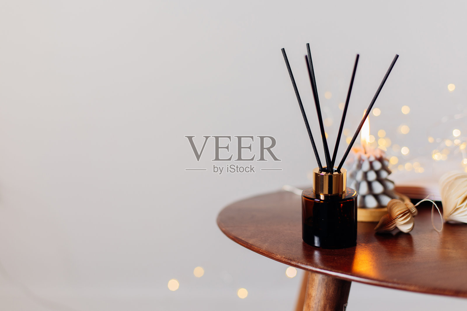 卧室木桌上的家用香氛扩散器和燃烧的蜡烛。室内元素。留白空间照片摄影图片