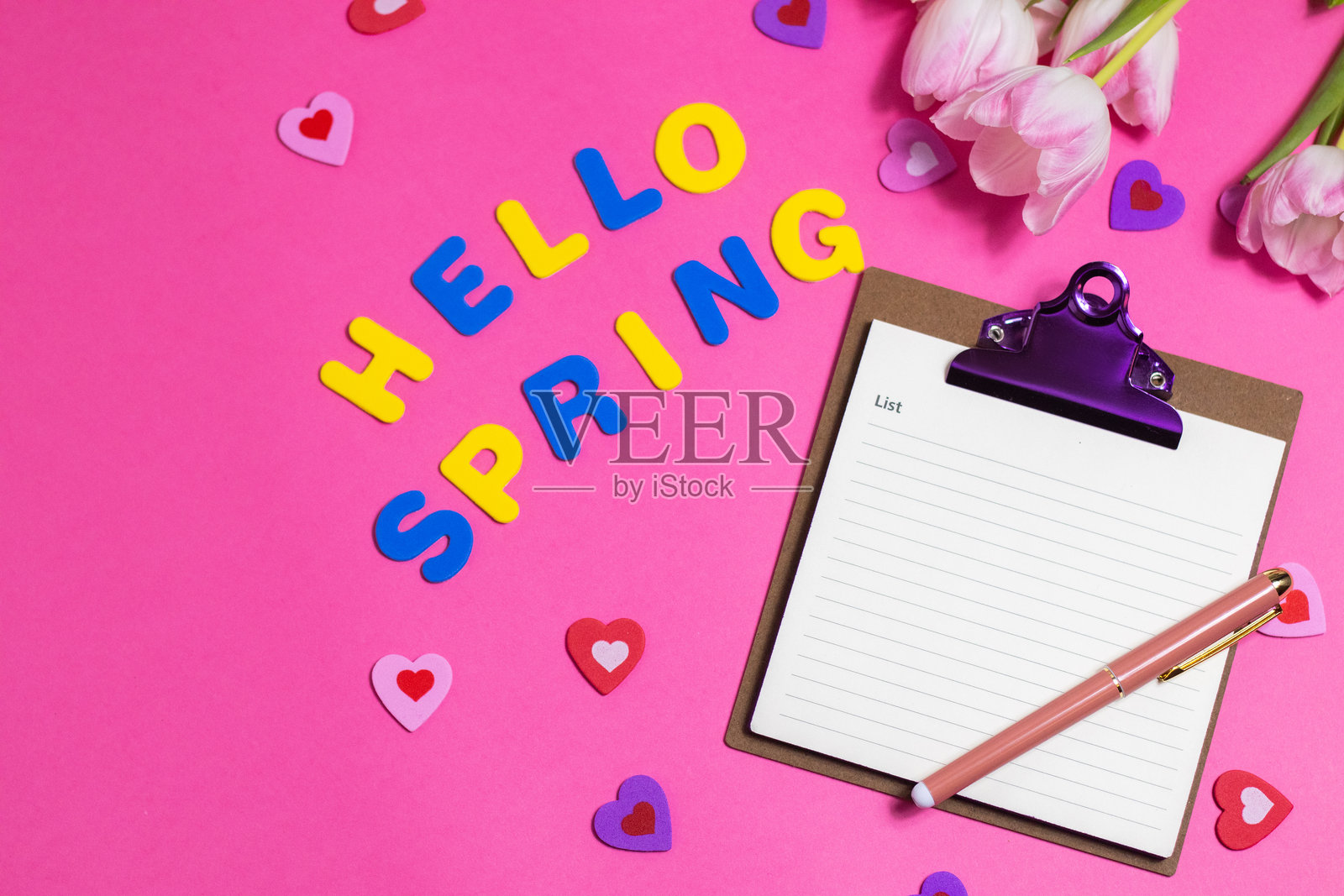 带有“你好春天”字样和美丽郁金香花朵的粉色背景构图照片摄影图片