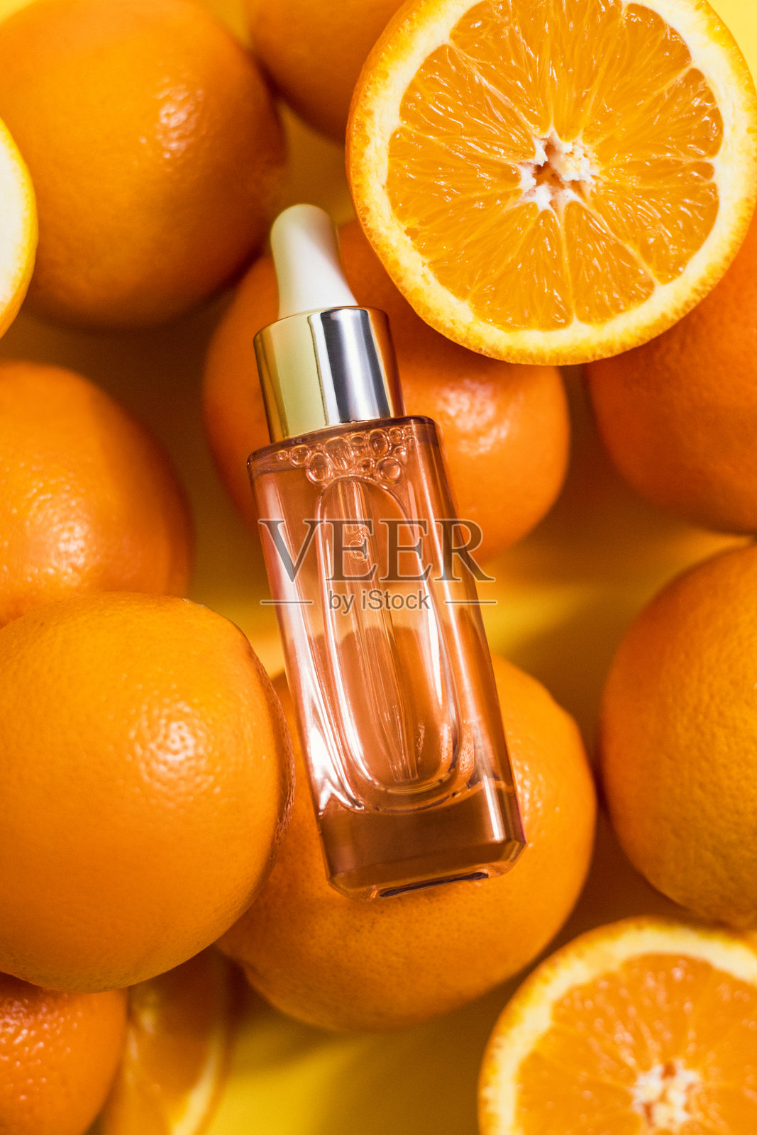 橙色和柠檬的维生素C美容瓶产品精华，平铺在黄色背景上，俯视图，留白空间照片摄影图片