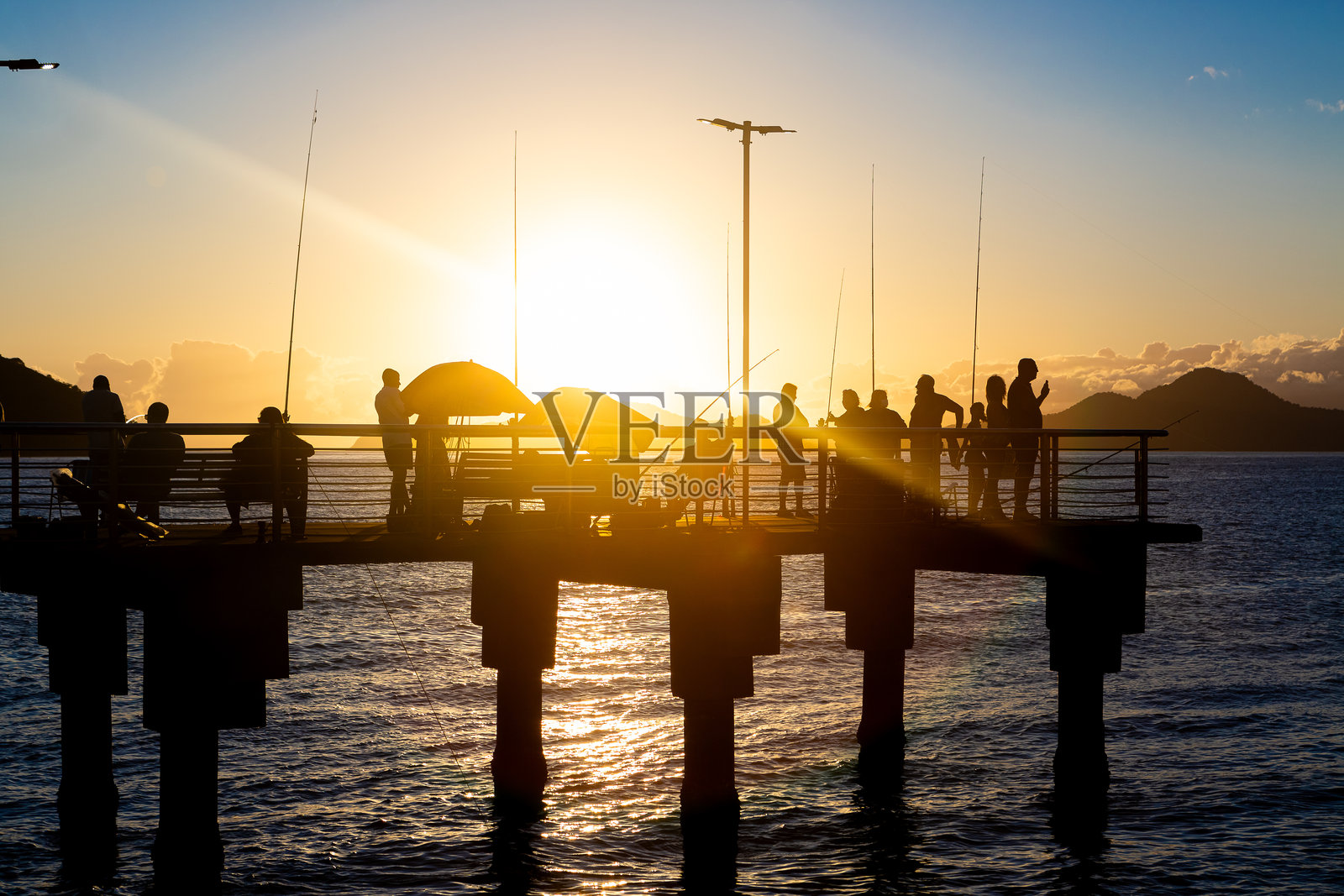 在桑托斯的渔民码头，夏季日落时分不明人物的剪影照片摄影图片
