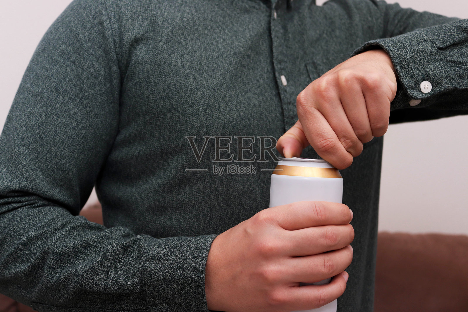 男人打开啤酒罐的特写镜头。照片摄影图片