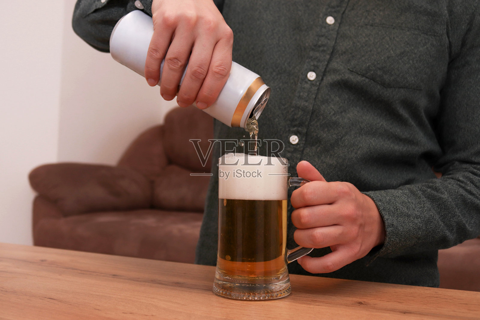 男子将啤酒从罐子倒入玻璃杯中照片摄影图片