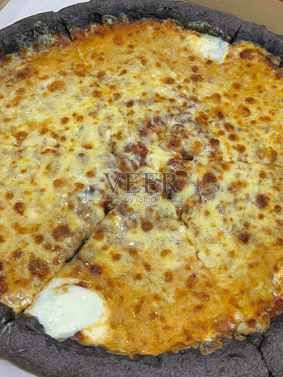 一款美味的披萨，金黄的外壳，融化的奶酪和美味的配料。非常适合与食品相关的设计、菜单或意大利主题项目，捕捉经典舒适菜肴的精髓。照片摄影图片