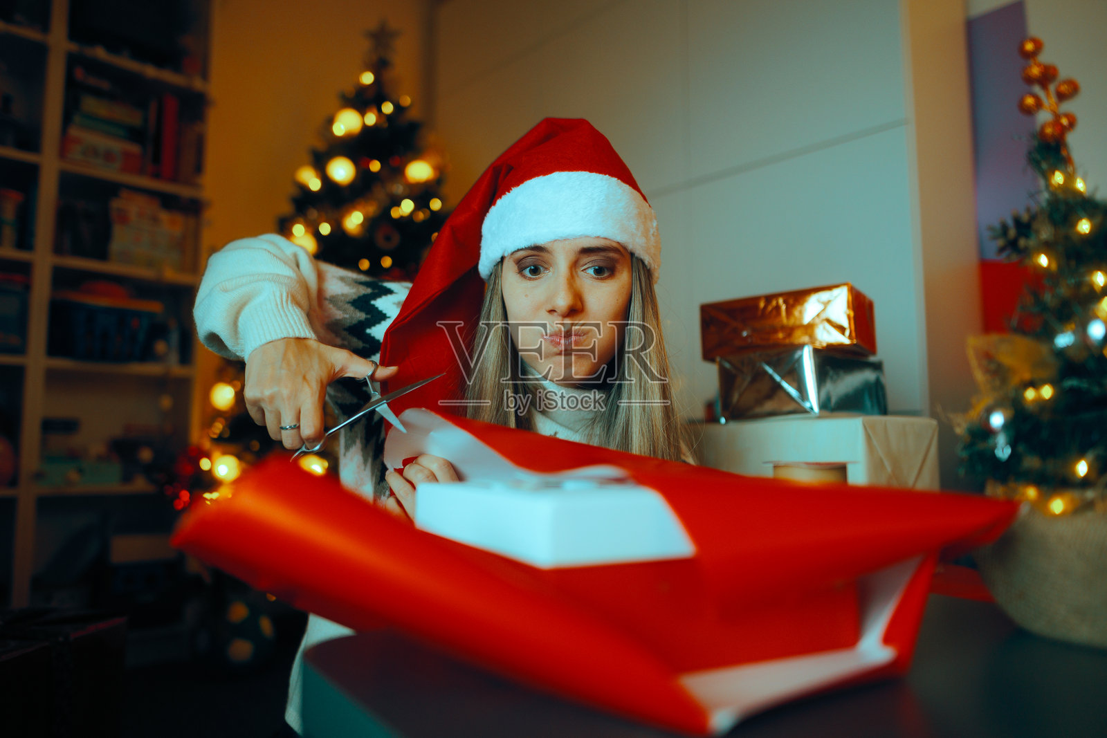 忙碌的圣诞女性正在用剪刀剪包装纸照片摄影图片