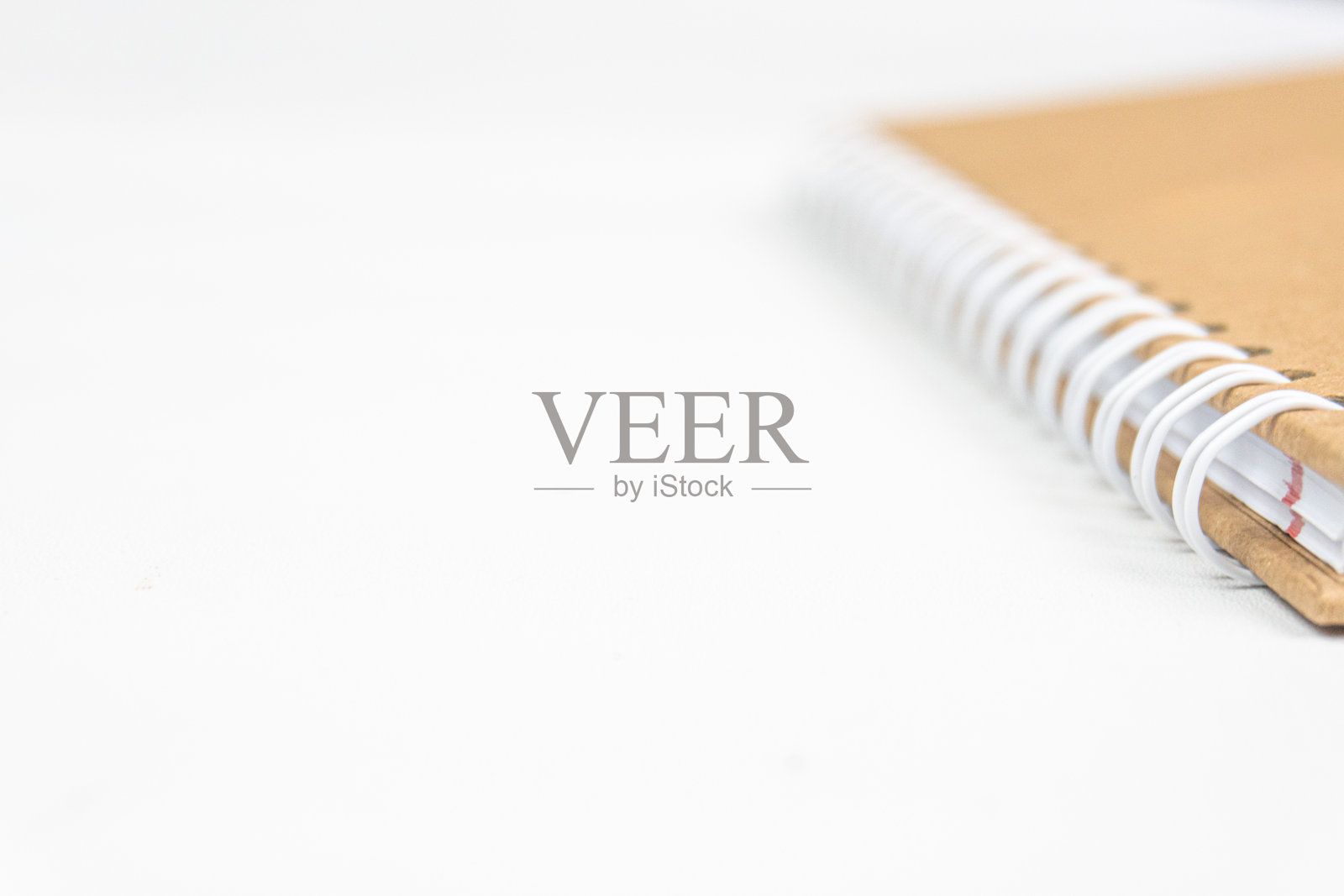 棕色笔记本上螺旋装订的特写，背景为白色照片摄影图片