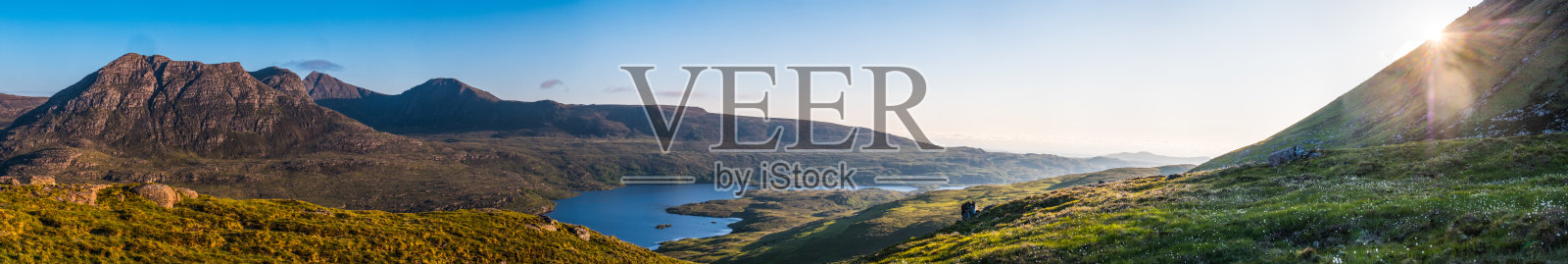 苏格兰金色日落全景，俯瞰科伊戈赫湖泊、山谷和高地山脉照片摄影图片