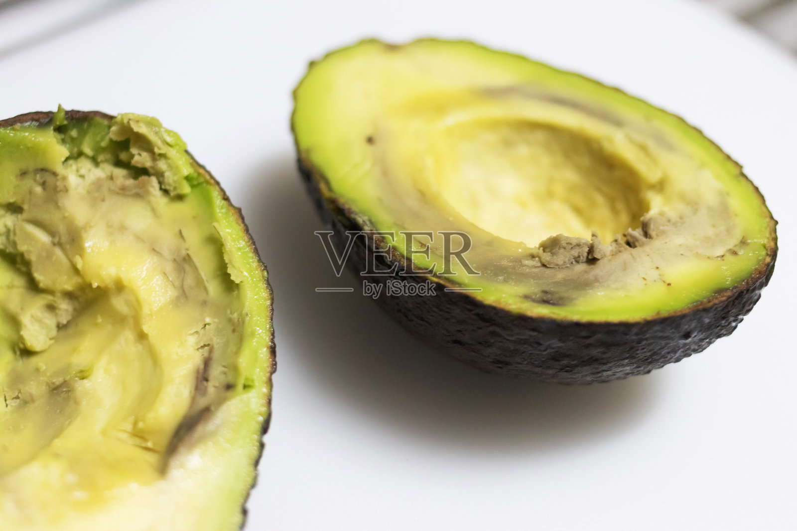 如果鳄梨在挤压时变得软烂，内部呈棕色或发霉，并且有变质或酸臭味，则它们已经腐烂。照片摄影图片