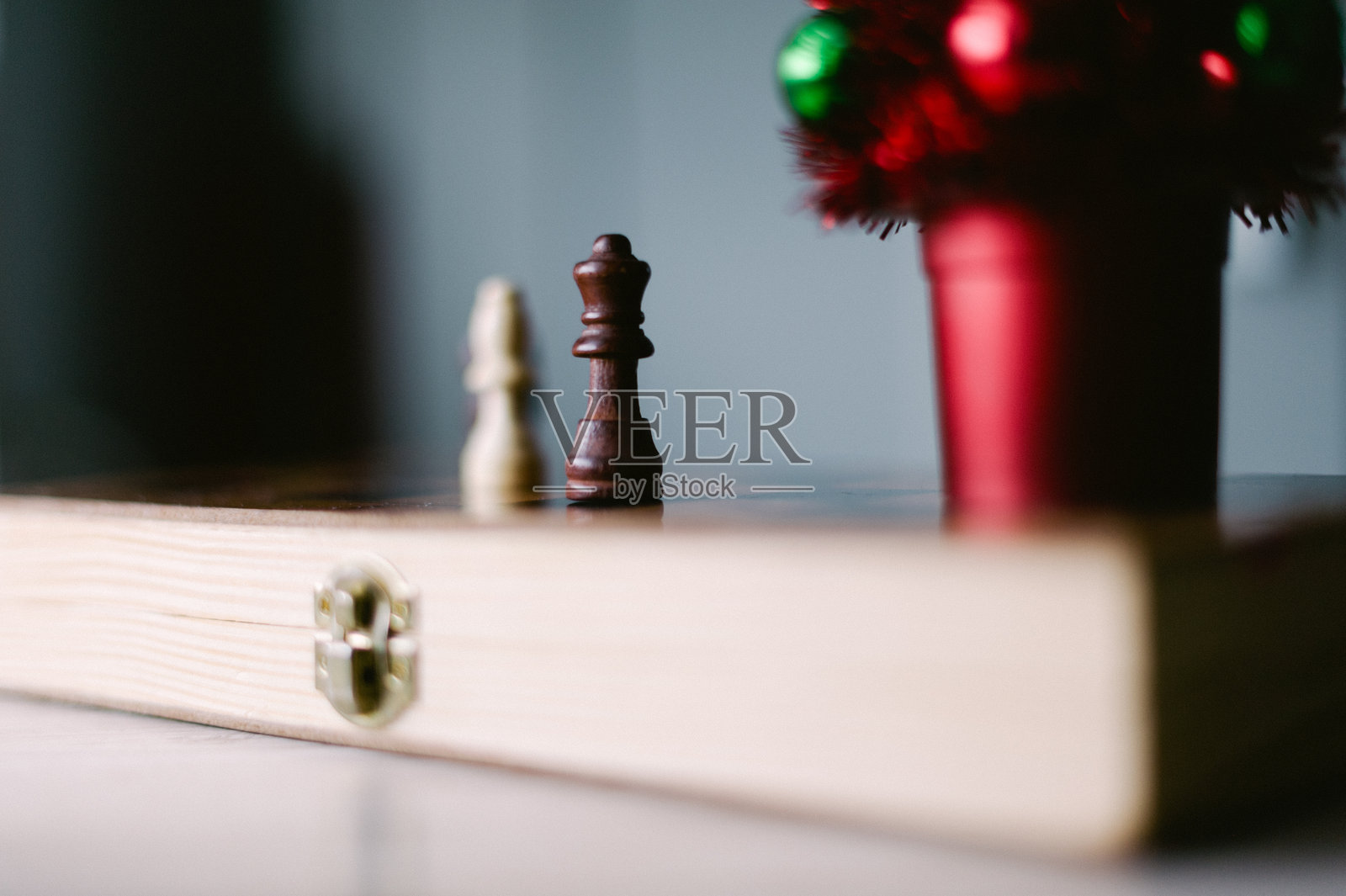 一张桌子上放着一个棋盘，上面有两个棋子，其中一个是国王。照片摄影图片