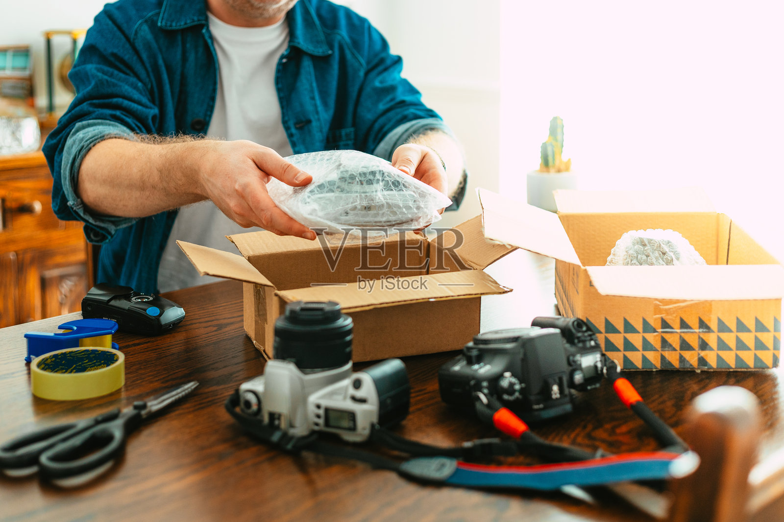 小企业主正在为客户打包模拟胶卷相机以便发货照片摄影图片