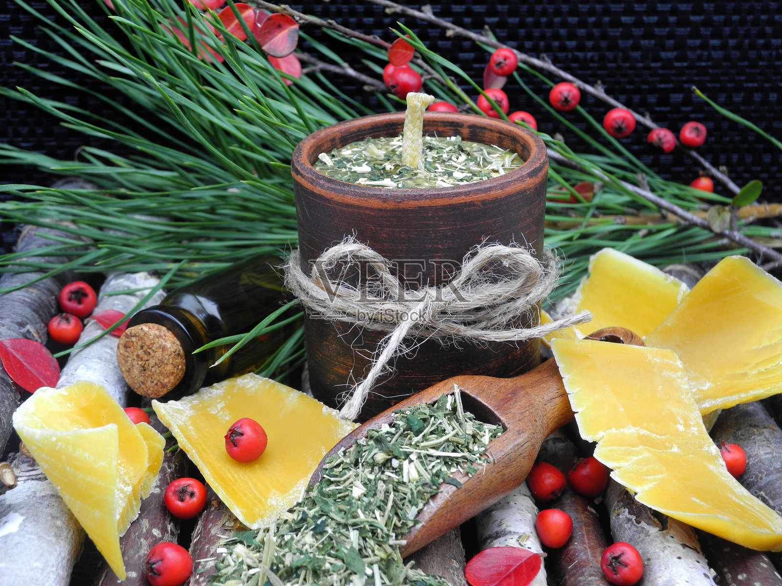 用天然成分和蜂蜡制作的草本蜡烛，放在陶土容器中照片摄影图片