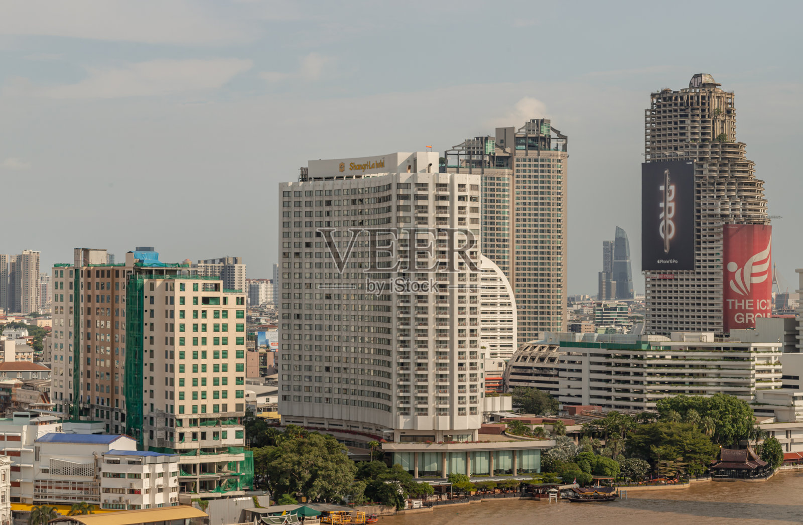 湄南河畔的香格里拉酒店和萨通独特大厦的摩天大楼视角，萨通独特“鬼塔”上的iPhone和The Icon Group广告标志。照片摄影图片