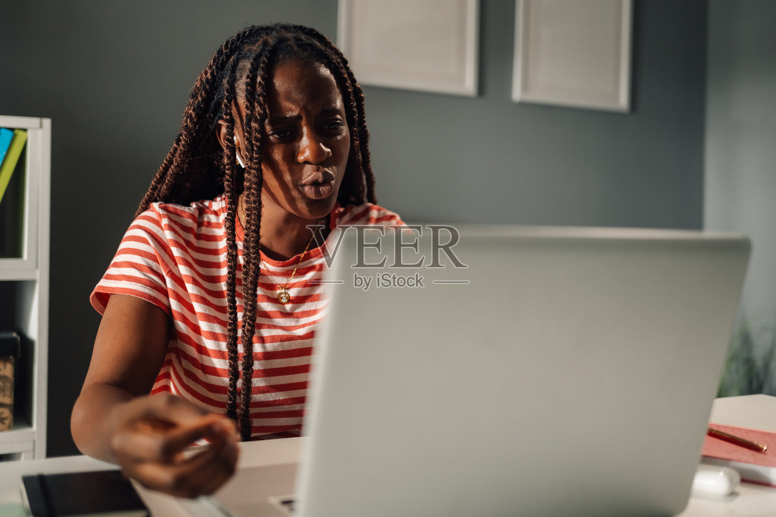 专注的黑人女性在家办公，正在通过笔记本电脑进行视频会议照片摄影图片