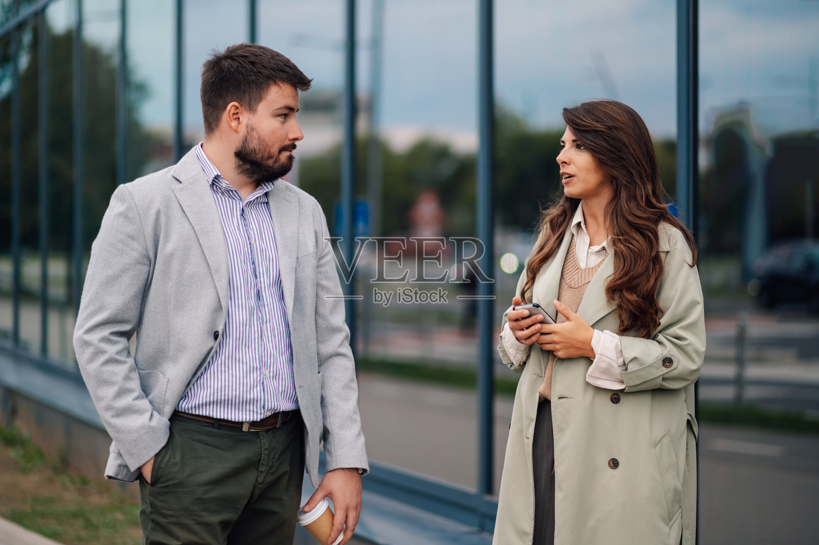 商业伙伴在办公楼附近散步时讨论项目照片摄影图片