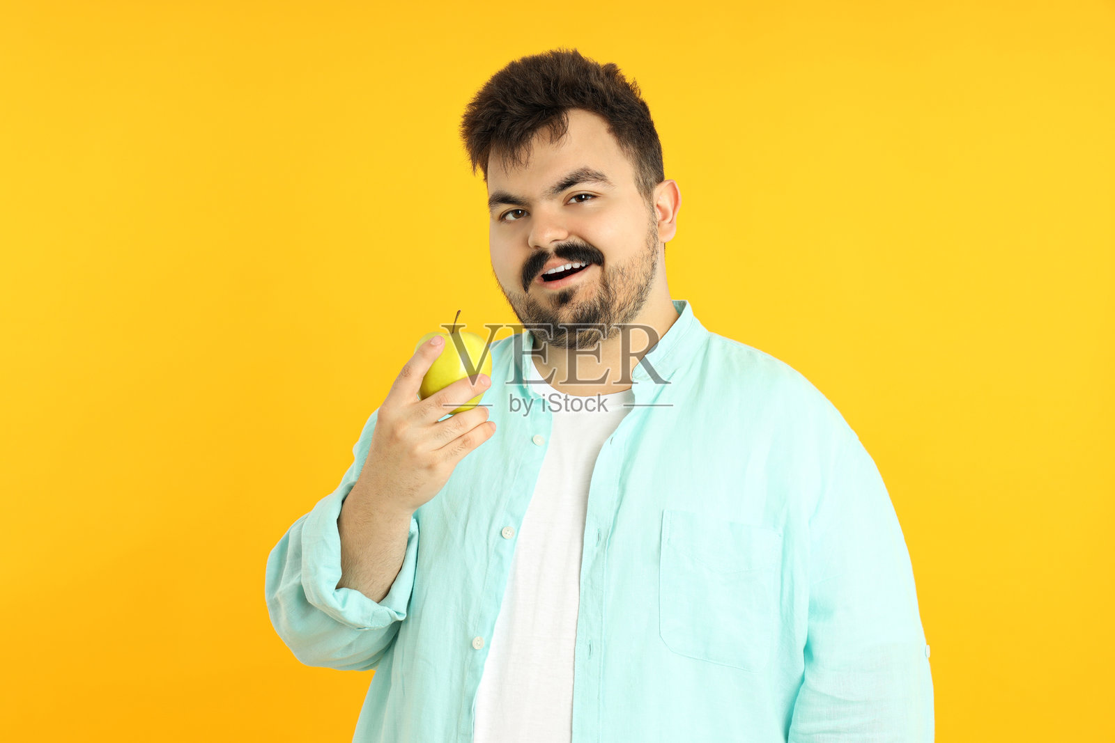 年轻胖男人的概念，背景为黄色照片摄影图片