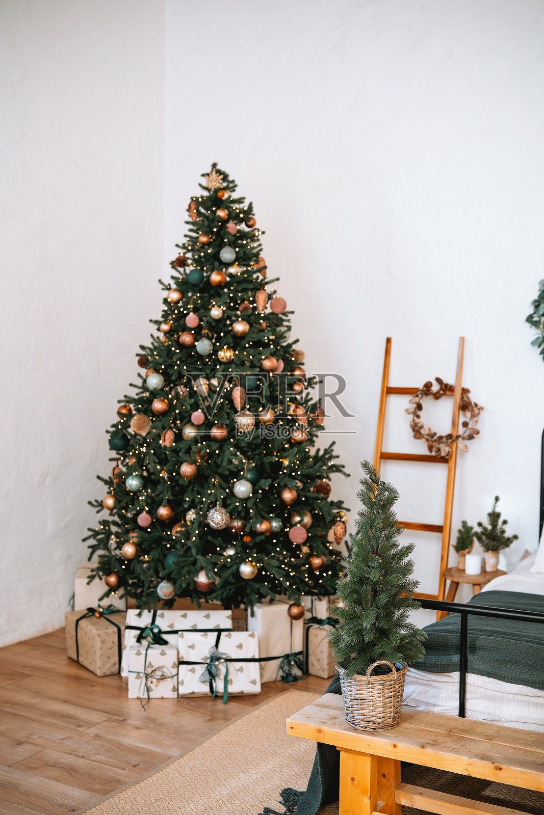 装饰华丽的圣诞树在温馨的客厅里，周围有礼物和节日装饰。照片摄影图片