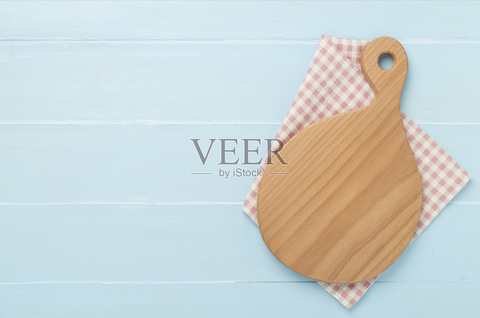 木质背景上的切菜板和餐巾，俯视图照片摄影图片
