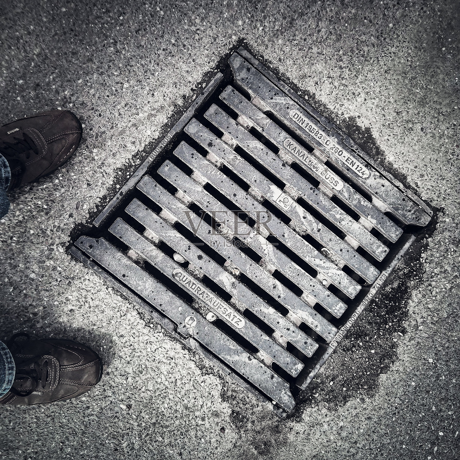 人腿在井盖旁照片摄影图片