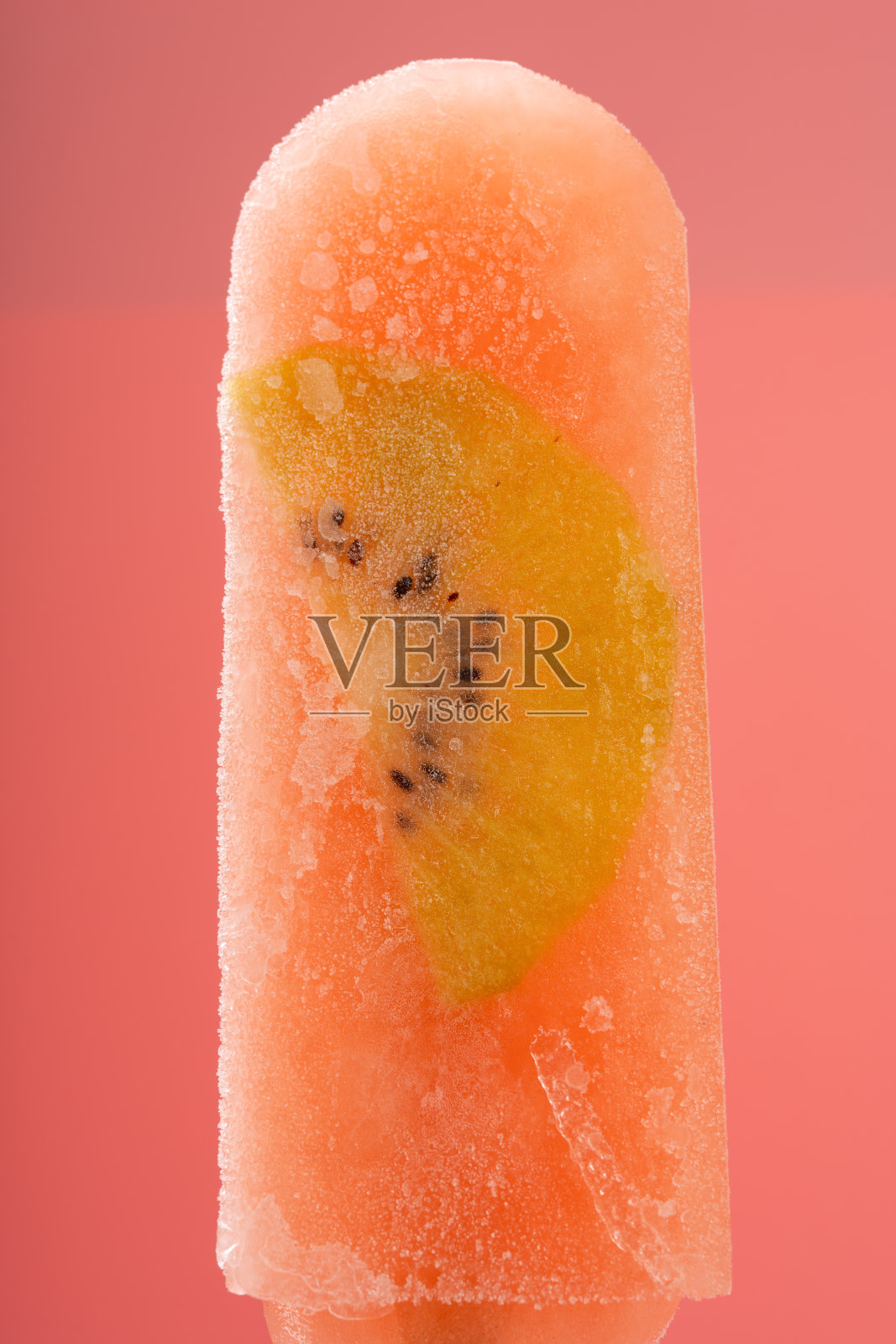 粉色背景上的新鲜桃子和乌龙茶口味的猕猴桃冰棒照片摄影图片