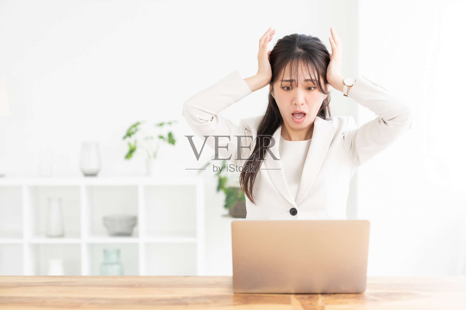 年轻的亚洲女商人使用笔记本电脑，遇到问题照片摄影图片