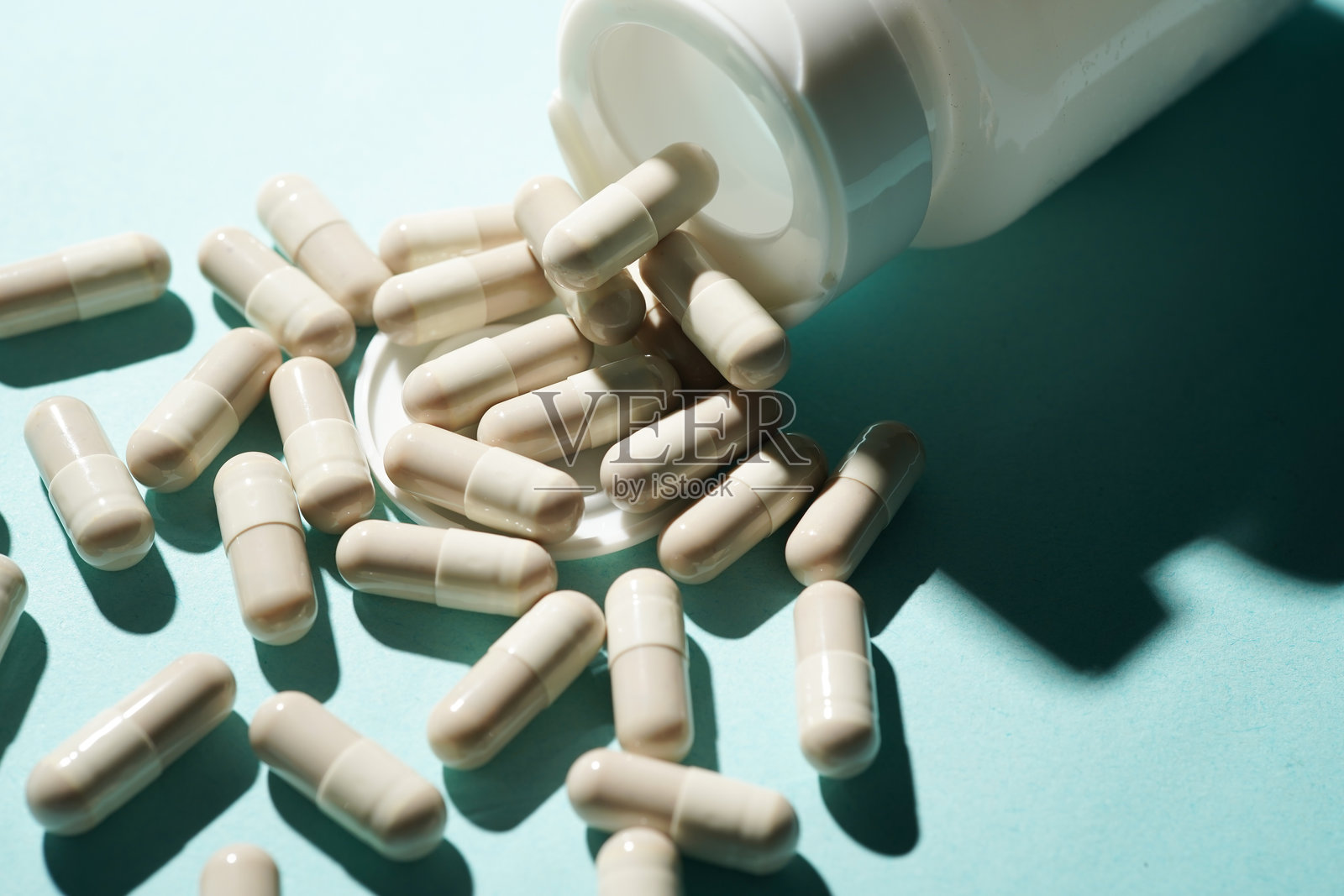 一组药丸胶囊，营养补充剂，维生素药片从瓶子里倾倒出来照片摄影图片