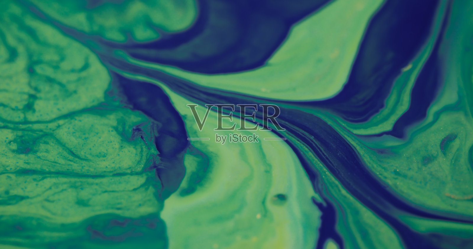 绿色泄漏的油漆溢出，平滑的溪流石头照片摄影图片