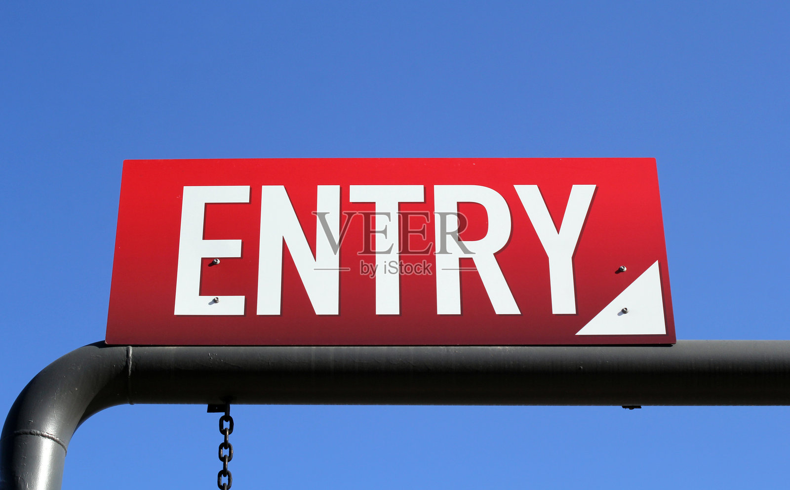 红色入口标志固定在黑色金属梁上，背景是清澈的蓝天照片摄影图片