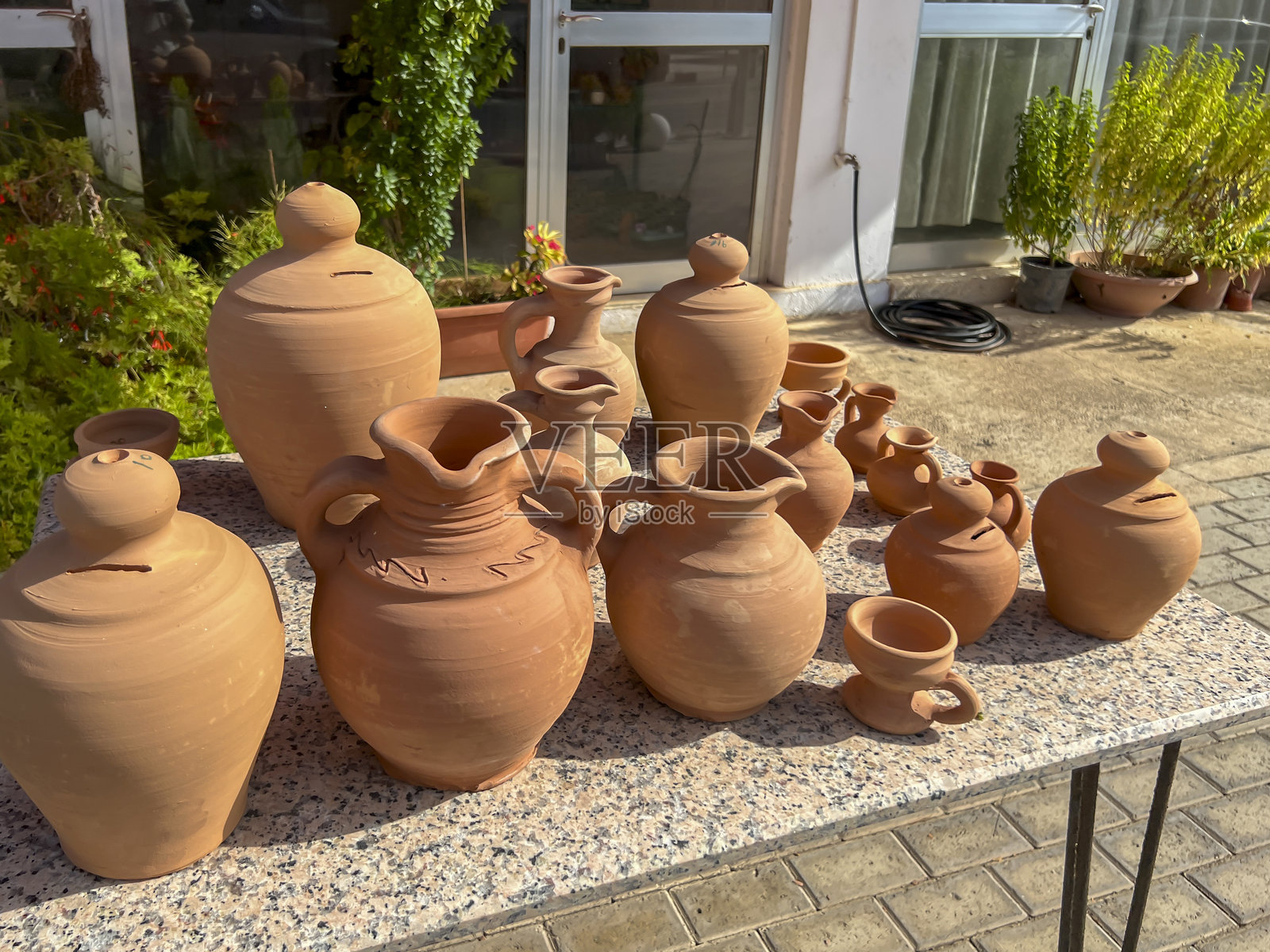 桌子上的陶土器皿、壶和花瓶，准备出售。塞浦路斯帕福斯地区。照片摄影图片