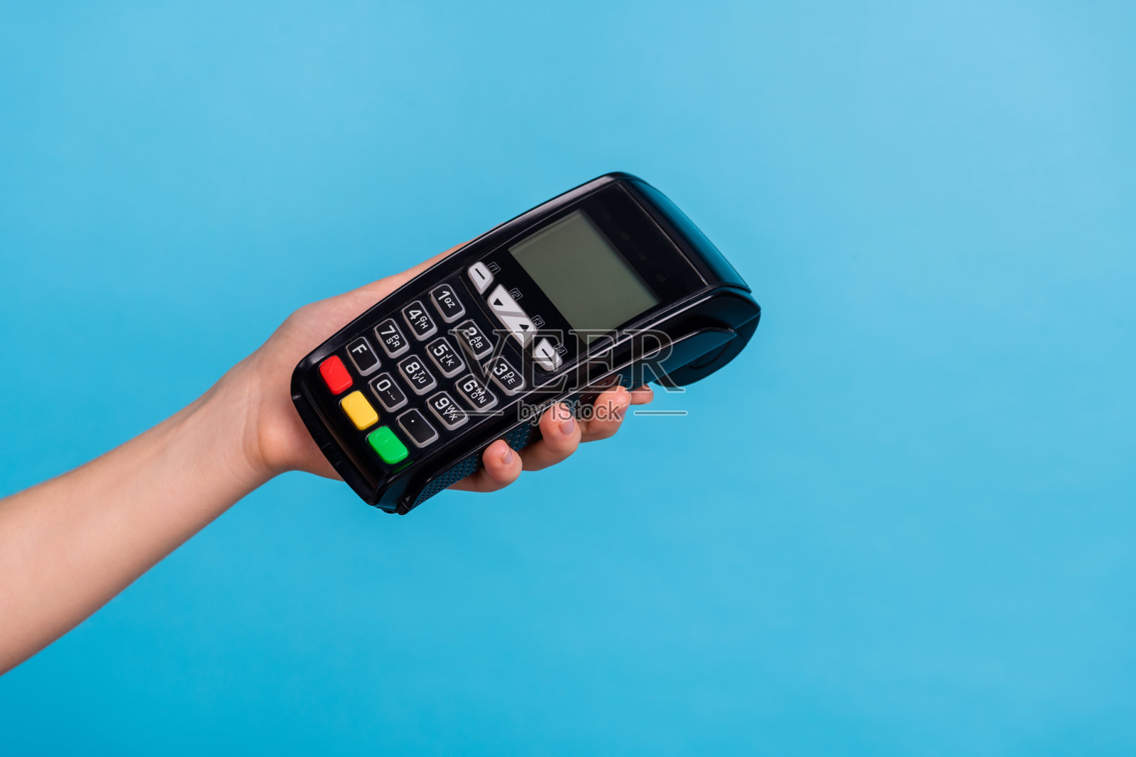 女性手持支付终端的特写肖像，背景为蓝色。照片摄影图片