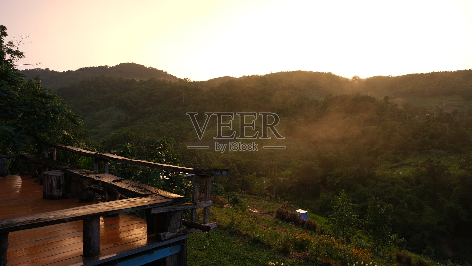 美丽的山景在日落时分，配有木质阳台。照片摄影图片