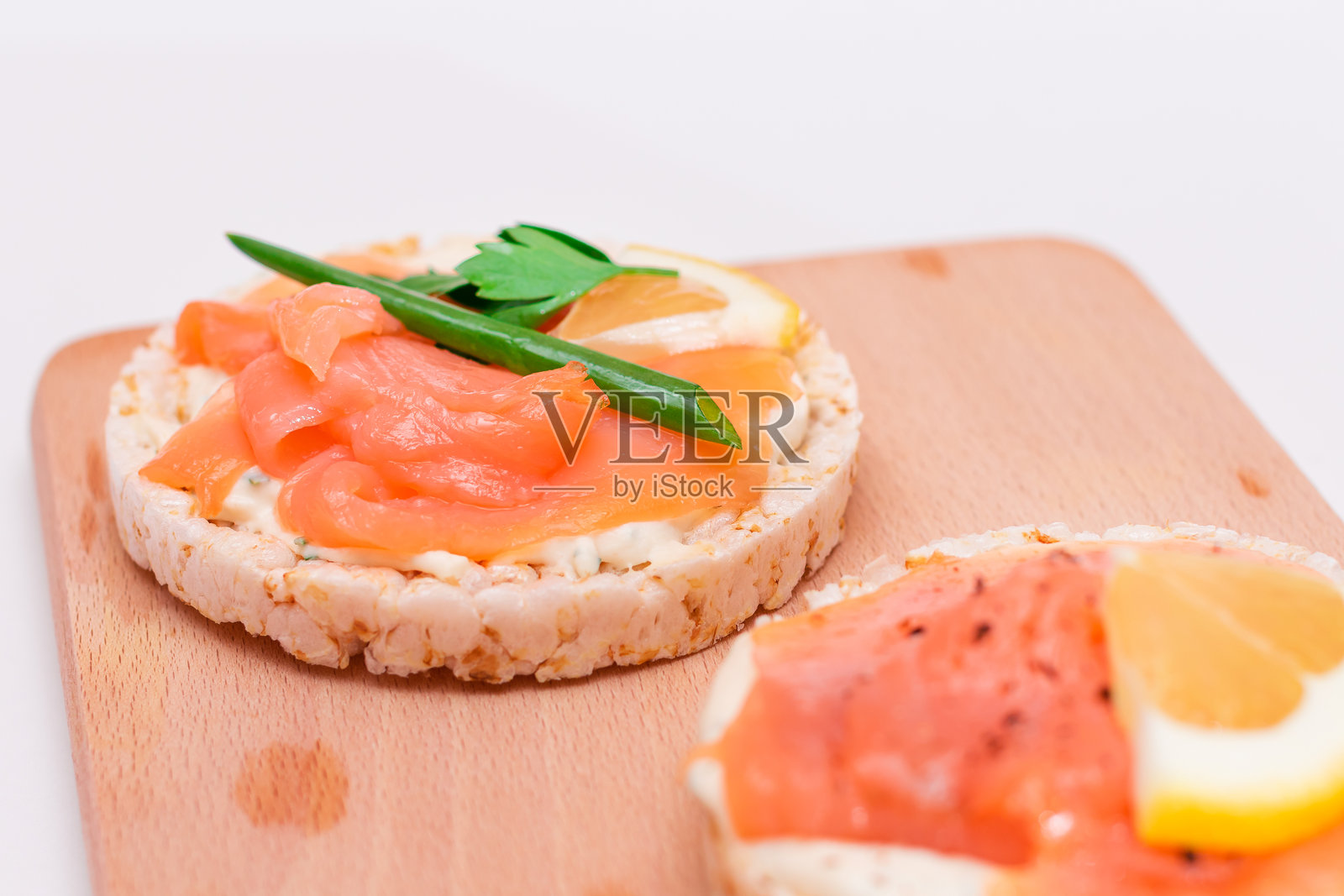 新鲜三文鱼、黄瓜、柠檬和绿叶蔬菜的米糕三明治照片摄影图片