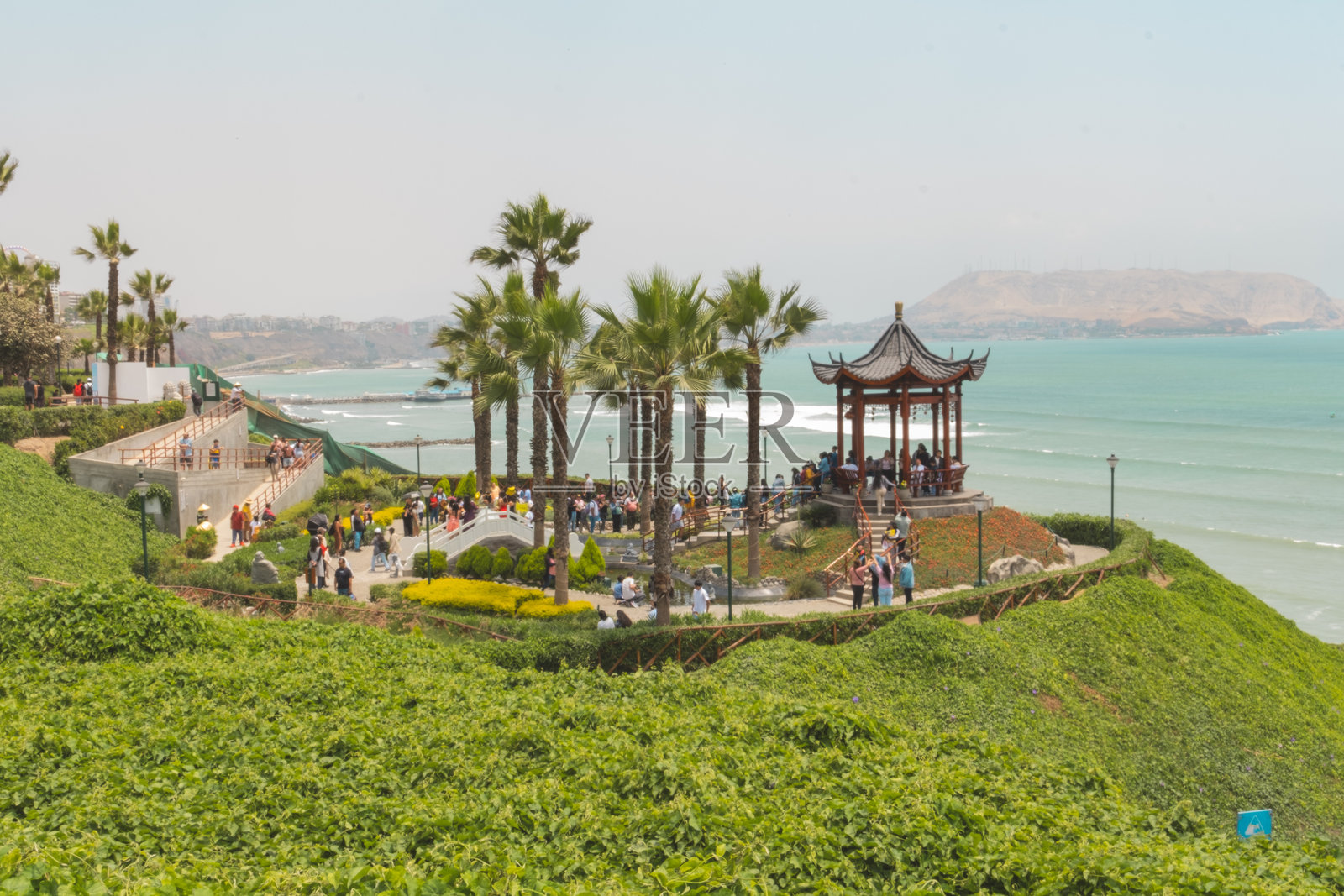 利马米拉弗洛雷斯的中国公园延时摄影，展示了亭子和绿意盎然的景观中的游客。照片摄影图片