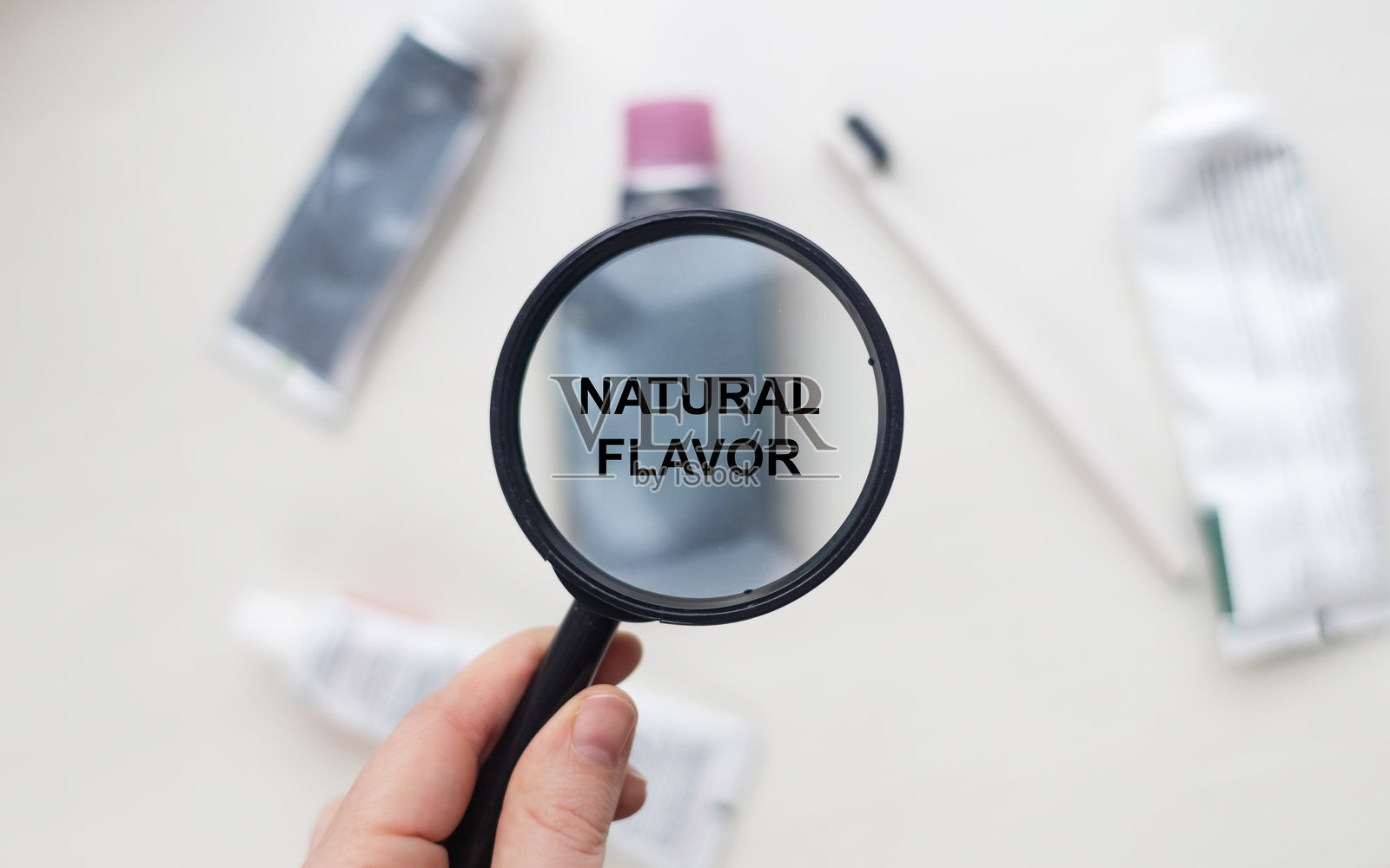 天然牙膏中的天然香料。放大镜对准一支安全产品的成分列表。安全牙膏成分。照片摄影图片